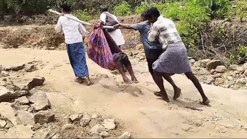 ಹನೂರು ತಾಲ್ಲೂಕಿನ ಮಲೆ ಮಹದೇಶ್ವರ ಬೆಟ್ಟ ಗ್ರಾಮ ಪಂಚಾಯಿತಿ ವ್ಯಾಪ್ತಿಯ ತುಳಸಿಕರೆ ಗ್ರಾಮದಲ್ಲಿ ಸಮರ್ಪಕ ರಸ್ತೆ ಸೌಲಭ್ಯ ಇಲ್ಲದೆ ಅನಾರೋಗ್ಯ ಪೀಡಿತ ವ್ಯಕ್ತಿಯನ್ನು ಜೋಳಿಗೆಯಲ್ಲಿ ಕಟ್ಟಿಕೊಂಡು ಆಸ್ಪತ್ರೆಗೆ ಹೊತ್ತೊಯ್ಯುತ್ತಿರುವುದು