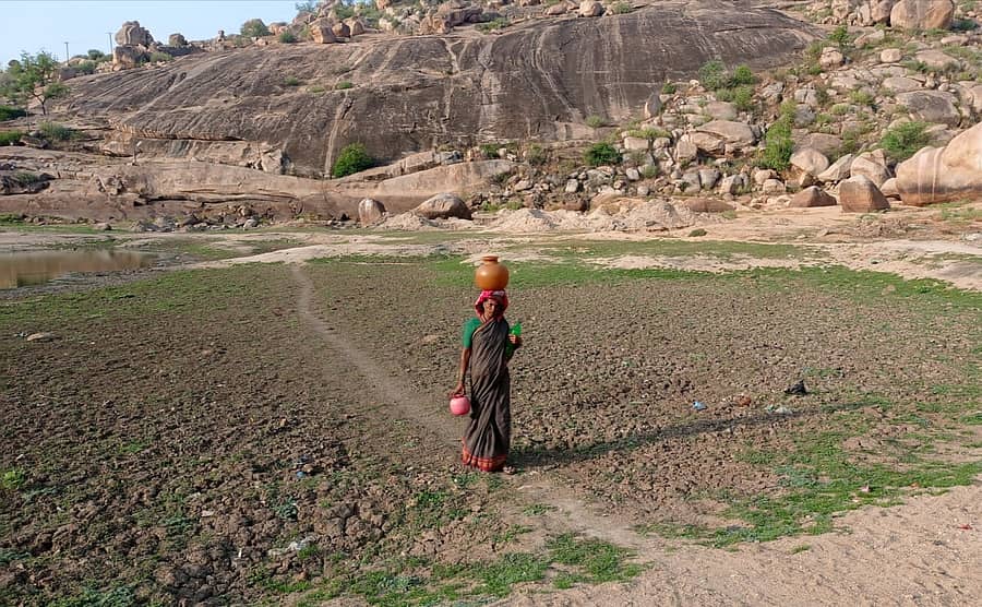ಮಾನ್ವಿ ಪಟ್ಡಣದ ಮಲ್ಲಿಕಾರ್ಜುನ ಬೆಟ್ಟದ ಸಮೀಪದ ಕೆರೆಯ ವರತಿ ನೀರು ಹೊತ್ತು ತರುತ್ತಿರುವ ಮಹಿಳೆ