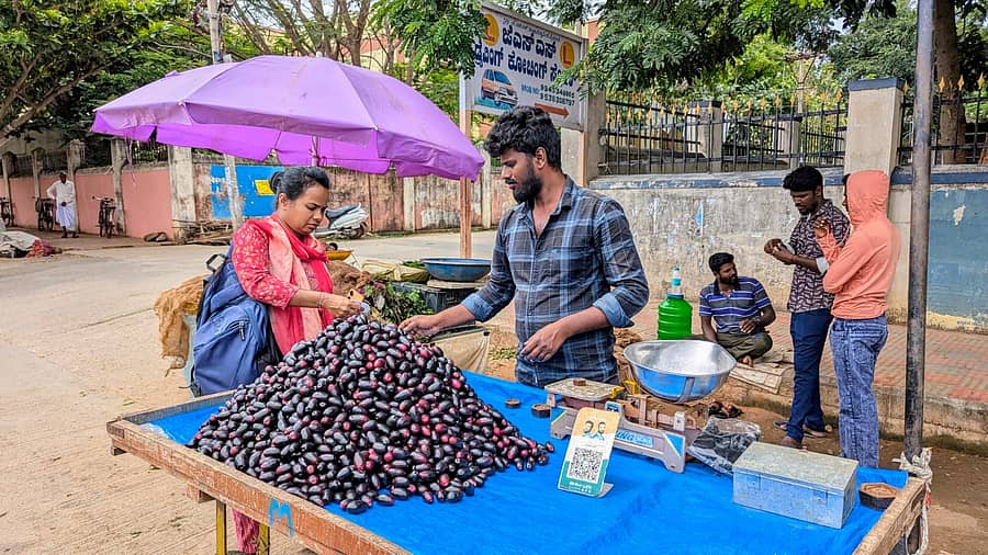 ಚಾಮರಾಜನಗರದ ಜೋಡಿ ರಸ್ತೆಯಲ್ಲಿ ನೇರಳೆ ಹಣ್ಣು ಖರೀದಿ ಮಾಡುತ್ತಿರುವ ಗ್ರಾಹಕರು