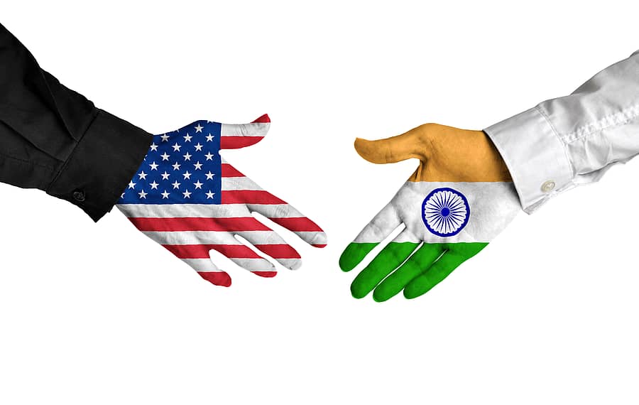 Diplomatic handshake between leaders from the United States and India with flag-painted hands.
United States and India leaders shaking hands on a deal