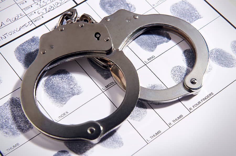 Handcuffs laying on top of fingerprint chart in file
arrest