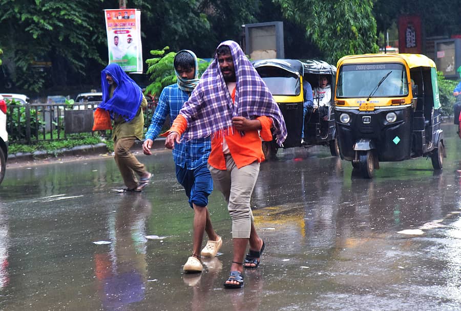 ಹುಬ್ಬಳ್ಳಿಗೆ ಗ್ರಾಮೀಣ ಭಾಗದಿಂದ ಬಂದಿದ್ದ ಜನರು ಮಳೆಯಲ್ಲಿ ನೆನೆದುಕೊಂಡು ಸಂಚರಿಸುವುದು ಲ್ಯಾಮಿಂಗ್ಟನ್‌ ಶಾಲೆ ಎದುರಿನ ರಸ್ತೆಯಲ್ಲಿ ಶುಕ್ರವಾರ ಕಂಡುಬಂತು 