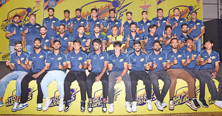 <div class="paragraphs"><p>ಮಹಾರಾಜ ಟ್ರೋಫಿಯಲ್ಲಿ ಆಡಲಿರುವ ‘ಮೈಸೂರು ವಾರಿಯರ್ಸ್‌’ ತಂಡದೊಂದಿಗೆ ನಾಯಕ ಕರುಣ್‌ ನಾಯರ್, ಮಾಲೀಕ ಅರ್ಜುನ್‌ ರಂಗಾ ಹಾಗೂ ಮುಖ್ಯಕೋಚ್‌ ಆರ್‌ಎಕ್ಸ್ ಮುರಳಿ</p></div>