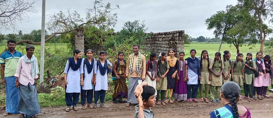ಅಳವಂಡಿ ಸಮೀಪದ ಹಲವಾಗಲಿ ಗ್ರಾಮದಲ್ಲಿ ಬಸ್ ನಿಲ್ದಾಣ ಇಲ್ಲದೇ ವಿದ್ಯಾರ್ಥಿಗಳು ಬಸ್‌ಗಾಗಿ ಕಾಯುತ್ತಿರುವುದು