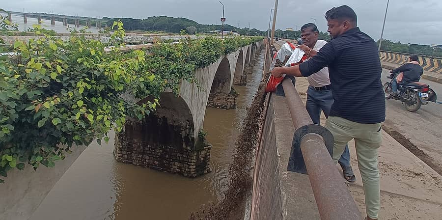 ಹರಿಹರದ ತುಂಗಭದ್ರಾ ಹೊಸ ಸೇತುವೆ ಮೇಲಿನ ಮಣ್ಣನ್ನು ನದಿಗೆ ಸುರಿಯುತ್ತಿರುವ ಪಿಡಬ್ಲ್ಯುಡಿ ಸಿಬ್ಬಂದಿ