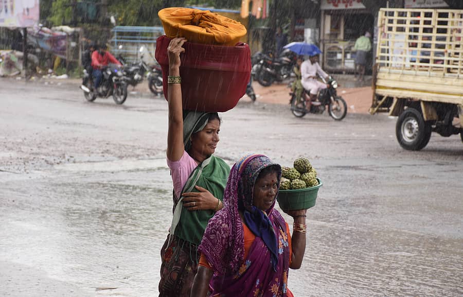 ಯಾದಗಿರಿ ನಗರದಲ್ಲಿ ಗುರುವಾರ ಸುರಿದ ಮಳೆಯಲ್ಲಿ ಸೀತಾಫಲ ಹಣ್ಣುಗಳ ಬುಟ್ಟಿ ಹೊತ್ತು ಸಾಗಿದ ಮಹಿಳೆಯರು