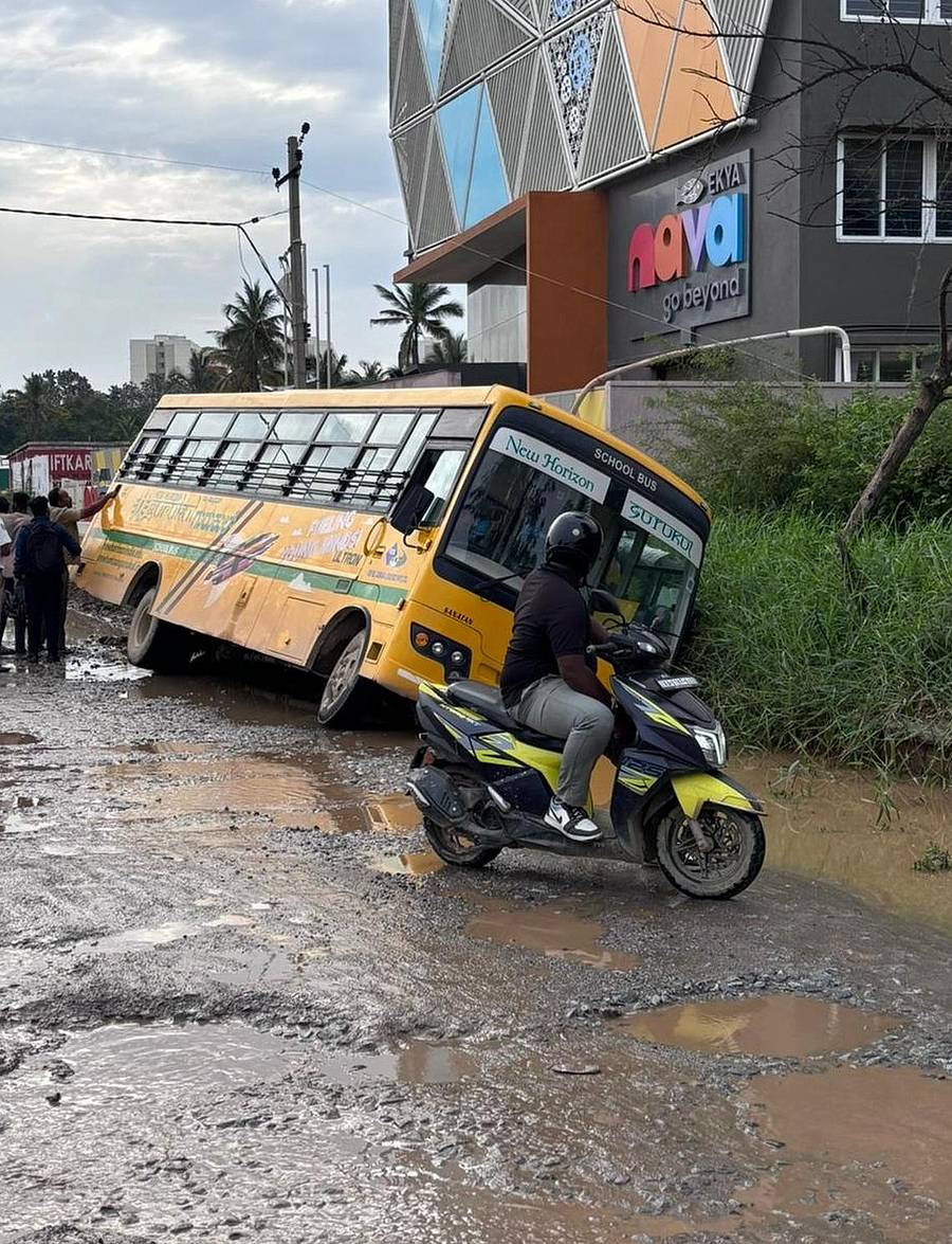 ರಸ್ತೆಯಲ್ಲಿ ಬಿದ್ದಿರುವ ಗುಂಡಿಯಿಂದ ವಾಲಿದ ಶಾಲಾ ಬಸ್