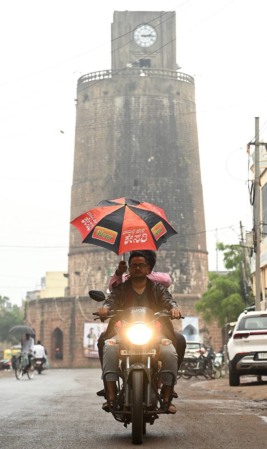 ಶನಿವಾರ ಸುರಿವ ಮಳೆಯಲ್ಲಿ ಬೈಕ್‌ ಸವಾರರಿಬ್ಬರೂ ಕೊಡೆ ಹಿಡಿದುಕೊಂಡು ಬೀದರ್‌ನ ಚೌಬಾರ ಮುಖ್ಯರಸ್ತೆಯಿಂದ ಹಾದು ಹೋದರು