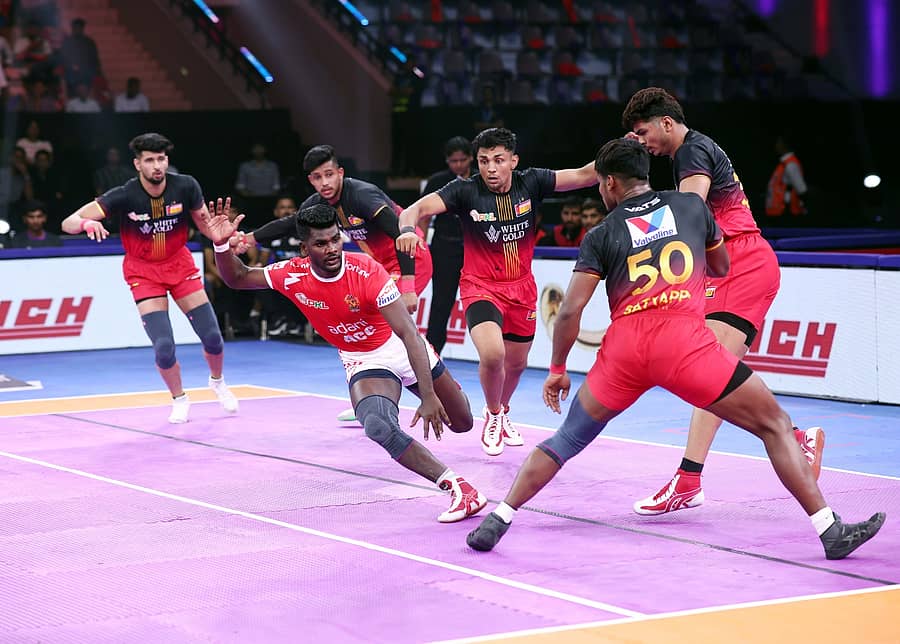 ಬೆಂಗಳೂರು ಬುಲ್ಸ್ ತಂಡದ ಆಟಗಾರರು ಗುಜರಾತ್ ತಂಡದ ರೇಡರ್ನನ್ನು ಟ್ಯಾಕಲ್ ಮಾಡಲು ಯತ್ನಿಸಿದರು