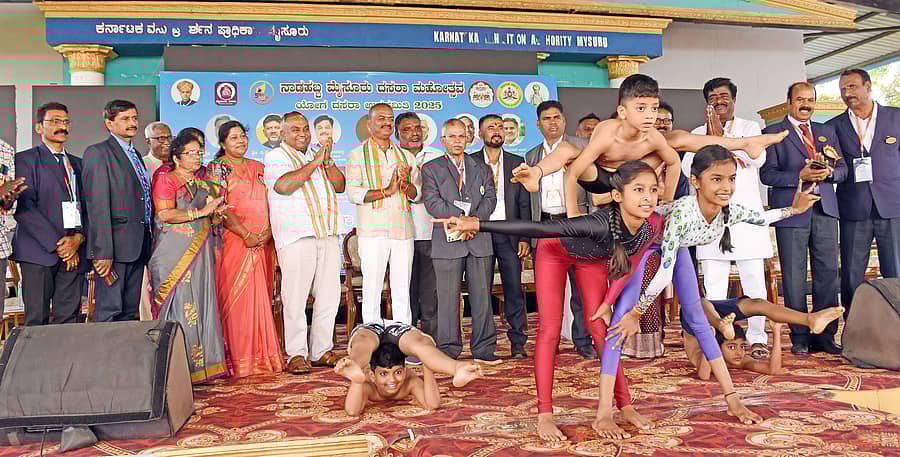 ಮೈಸೂರು ವಸ್ತು ಪ್ರದರ್ಶನ ಪ್ರಾಧಿಕಾರ ಆವರಣದಲ್ಲಿ ಶನಿವಾರ ರಾಜ್ಯಮಟ್ಟದ ಯೋಗಾಸನ ಸ್ಪರ್ಧೆ ಉದ್ಘಾಟನೆಯಲ್ಲಿ ವಿವಿಧ ಯೋಗ ಭಂಗಿ ಪ್ರದರ್ಶಿಸಿದ ಸ್ಪರ್ಧಿಗಳು. ಟಿ.ಎಸ್.ಶ್ರೀವತ್ಸ, ಎನ್.ನಾಗೇಶ್, ಕೆ.ರಮ್ಯಾ, ನಿರೂಪ್ ವೆಸ್ಲಿ ಹಾಜರಿದ್ದರು