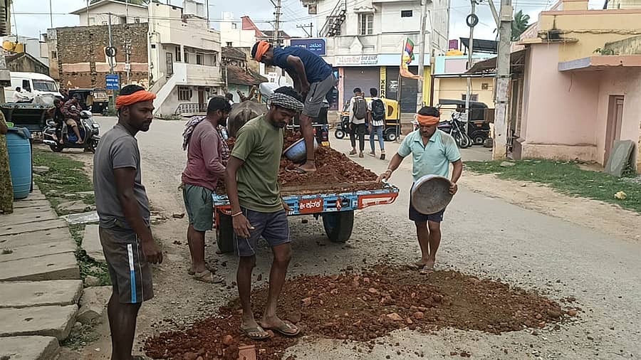 ರಾಣೆಬೆನ್ನೂರಿನ ಮಾಸೂರು–ಮುಂಡರಗಿ ರಾಜ್ಯ ಹೆದ್ದಾರಿಯ ದೇವರಗುಡ್ಡ ರಸ್ತೆಯಲ್ಲಿ ಬಿದ್ದಿರುವ ಗುಂಡಿಗಳನ್ನು ಹಮಾಲರು ಮುಚ್ಚಿದರು