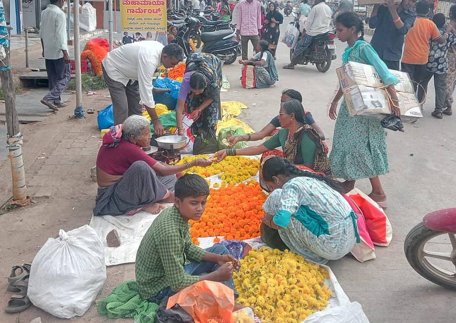 ಕುಕನೂರಿನ ವೀರಭದ್ರಪ್ಪ ವೃತ್ತದಲ್ಲಿ ಚಂಡು ಹೂ ಖರೀದಿಸುತ್ತಿರುವ ಗ್ರಾಹಕರು