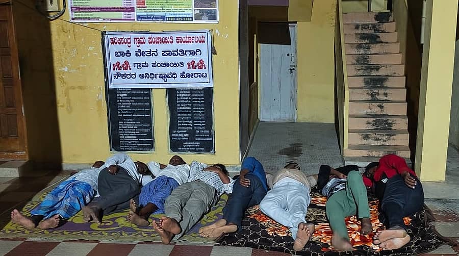 ವೇತನ ಬಿಡುಗಡೆಗೆ ಆಗ್ರಹಿಸಿ ಹರೀಸಂದ್ರ ಗ್ರಾಮ ಪಂಚಾಯಿತಿಯ ವಾಟರ್ಮ್ಯಾನ್ಗಳು ಹಾಗೂ ಬಿಲ್ ಕಲೆಕ್ಟರ್ಗಳು ಪಂಚಾಯಿತಿ ಕಚೇರಿ ಎದುರು ಗುರುವಾರ ಧರಣಿ ನಡೆಸಿ, ಅಲ್ಲಿಯೇ ಮಲಗಿದ್ದ ದೃಶ್ಯ