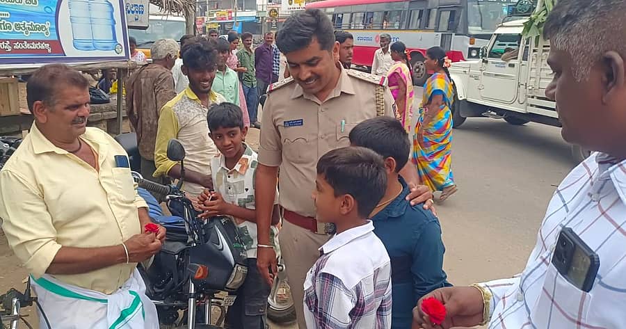 ಸಂತೇಮರಹಳ್ಳಿಯಲ್ಲಿ ಶಾಲಾ ವಿದ್ಯಾರ್ಥಿಗಳಿಂದ ಗುಲಾಬಿ ಹೂ ನೀಡುವ ಮೂಲಕ ವಾಹನ ಸವಾರರಿಗೆ ಸಂಚಾರಿ ನಿಯಮ ಅರಿವು ಮೂಡಿಸಲಾಯಿತು