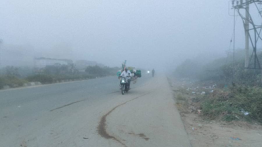 ದಟ್ಟ ಮಂಜಿನ ವಾತಾವರಣದಲ್ಲಿ ವ್ಯಕ್ತಿಯೊಬ್ಬರು ದ್ವಿಚಕ್ರ ವಾಹನದಲ್ಲಿ ಬರುತ್ತಿರುವ ದೃಶ್ಯ