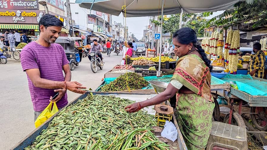 ಚಾಮರಾಜನಗರದ ಚಾಮರಾಜೇಶ್ವರ ದೇವಸ್ಥಾನದ ಹಿಂಭಾಗ ವ್ಯಾಪಾರಿಯೊಬ್ಬರು ಗ್ರಾಹಕರಿಗೆ ಅವರೇಕಾಯಿ ತೊಗರಿಕಾಯಿ ಮಾರಾಟ ಮಾಡುತ್ತಿರುವುದು