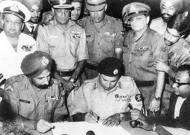 <div class="paragraphs"><p>1971ರ ಡಿಸೆಂಬರ್ 16ರಂದು ಢಾಕಾದಲ್ಲಿ ಪಾಕಿಸ್ತಾನದ ಲೆಫ್ಟಿನಂಟ್ ಜನರಲ್ ಎ.ಎ.ಕೆ. ನಿಯಾಜಿ ಅವರು ಭಾರತದ ಲೆಫ್ಟಿನಂಟ್ ಜನರಲ್ ಅರೋರಾ ಅವರ ಉಪಸ್ಥಿತಿಯಲ್ಲಿ (ಎಡತುದಿ) ಶರಣಾಗತಿ ಪತ್ರಕ್ಕೆ ಸಹಿ ಹಾಕಿದ ಕ್ಷಣ.</p></div><div class="paragraphs"><p><br></p></div>