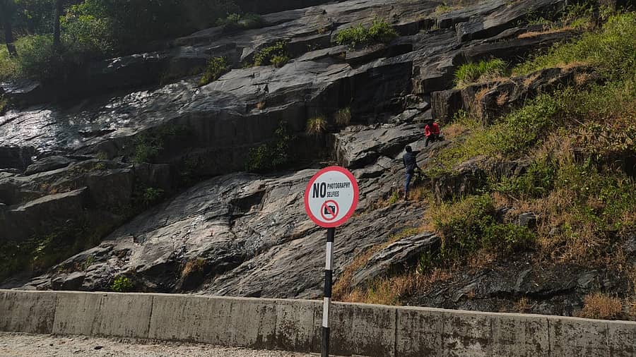 ಮೂಡಿಗೆರೆ ತಾಲ್ಲೂಕಿನ ಚಾರ್ಮಾಡಿ ಘಾಟಿಯಲ್ಲಿ ಎಚ್ಚರಿಕೆಯ ನಾಮಫಲಕದ ಬಳಿಯೇ ಪ್ರವಾಸಿಗರು ಕಲ್ಲು ಬಂಡೆಗಳ ಮೇಲೆ ಏರುತ್ತಿದ್ದರು