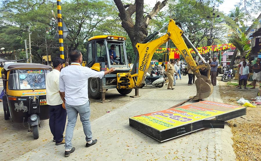 ಮಂಡ್ಯ ನಗರದಲ್ಲಿ ಹೆದ್ದಾರಿಯ ಪಾದಚಾರಿ ಮಾರ್ಗದ ಸ್ಥಳಗಳಲ್ಲಿದ್ದ ನಾಮಫಲಕಗಳನ್ನು ನಗರಸಭೆ ಹಾಗೂ ರಾಷ್ಟ್ರೀಯ ಹೆದ್ದಾರಿ ಪ್ರಾಧಿಕಾರದ ಅಧಿಕಾರಿಗಳು ಜೆಸಿಬಿ ಮೂಲಕ ತೆರವುಗೊಳಿಸಿದರು 