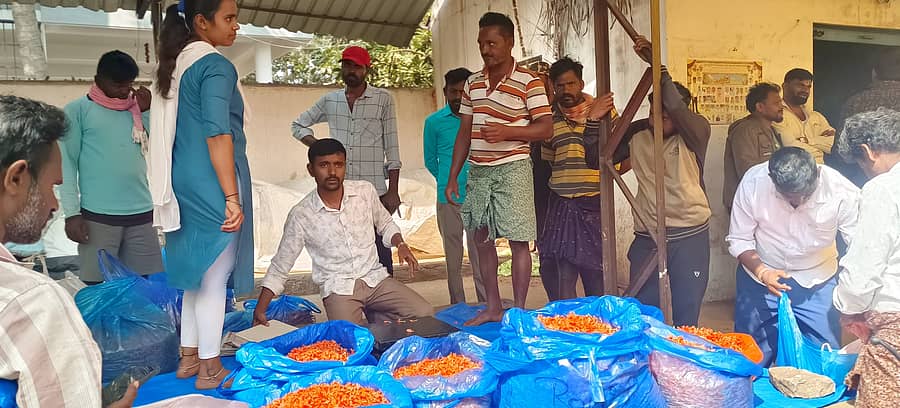 ಬಡವನಹಳ್ಳಿ ಮಂಡಿಯಲ್ಲಿ ಬೆಳೆಗಾರರಿಂದ ಹೂವು ಖರೀದಿಸುತ್ತಿರುವ ವ್ಯಾಪಾರಿ