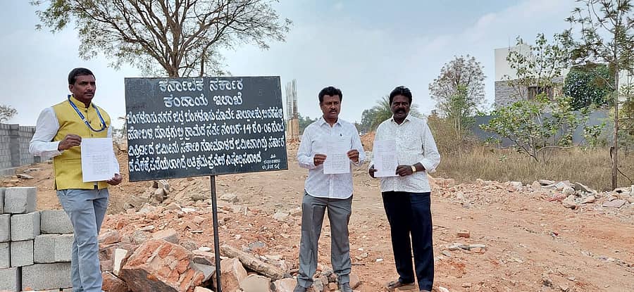 ಅಪಾರ್ಟ್ಮೆಂಟ್ಗೆ ರಸ್ತೆ ಕಲ್ಪಿಸಲು ಸರ್ಕಾರಿ ಜಾಗವನ್ನು ಬಳಸಲಾಗುತ್ತಿದೆ ಎಂದು ದೊಡ್ಡಗುಬ್ಬಿ ಗ್ರಾಮಸ್ಥರು ಜಿಲ್ಲಾಡಳಿತದ ಫಲಕದ ಮುಂದೆ ಪ್ರತಿಭಟಿಸಿದರು