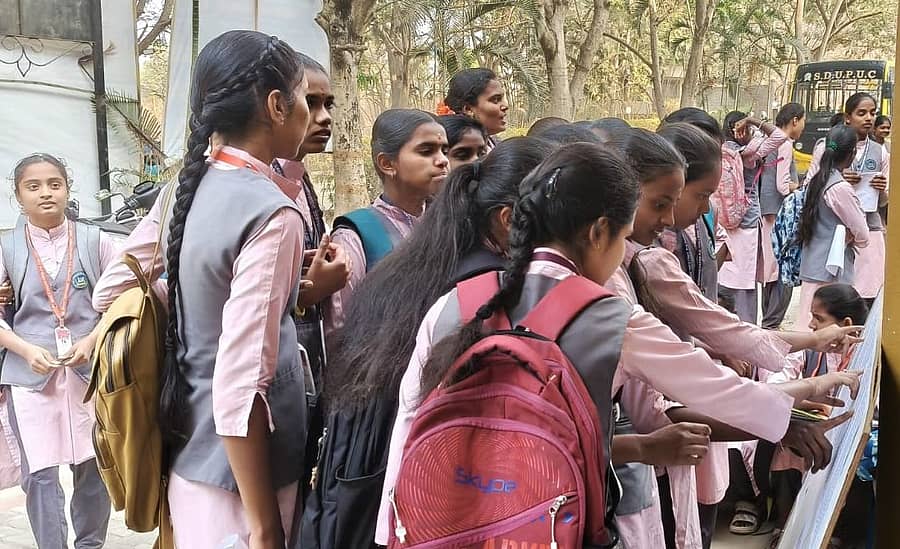 ದೊಡ್ಡಬಳ್ಳಾಪುರದ ಶ್ರೀ ದೇವರಾಜ ಅರಸು ಪದವಿ ಪೂರ್ವ ಕಾಲೇಜು ದ್ವಿತೀಯ ಪಿಯುಸಿ ಪರೀಕ್ಷಾ ಕೇಂದ್ರದಲ್ಲಿ  ನೋಂದಣಿ ಸಂಖ್ಯೆಯನ್ನು ಪರಿಶೀಲಿಸಿಕೊಳ್ಳುತ್ತಿರುವ ವಿದ್ಯಾರ್ಥಿಗಳು