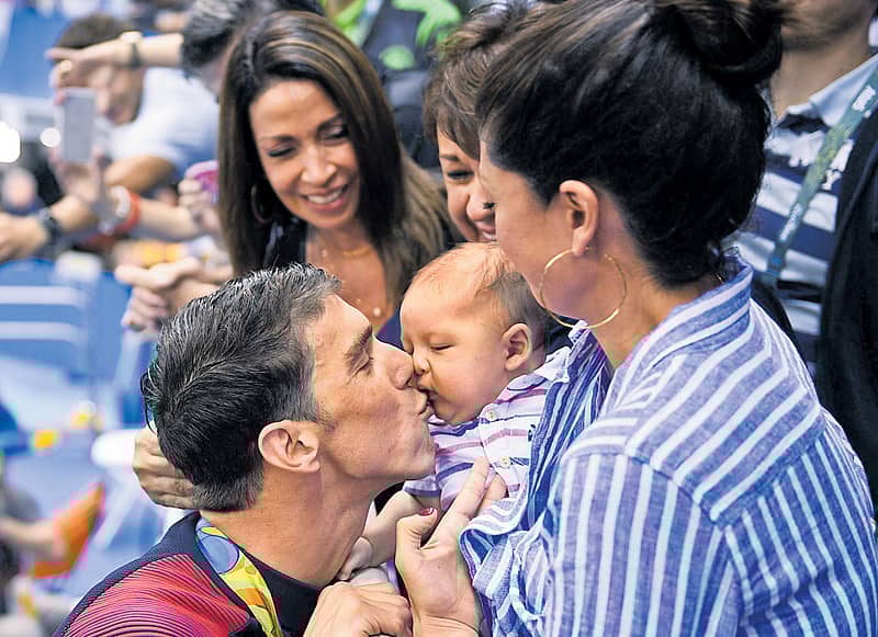 ತಮ್ಮ ಮಗ ಬೂಮರ್‌ಗೆ ಸಿಹಿಮುತ್ತು ನೀಡಿದ ಮೈಕೆಲ್ ಫೆಲ್ಪ್ಸ್ .  ಪತ್ನಿ ನಿಕೋಲ್ ಜಾನ್ಸನ್ ಇದ್ದಾರೆ   ಎಎಫ್‌ಪಿ ಚಿತ್ರ