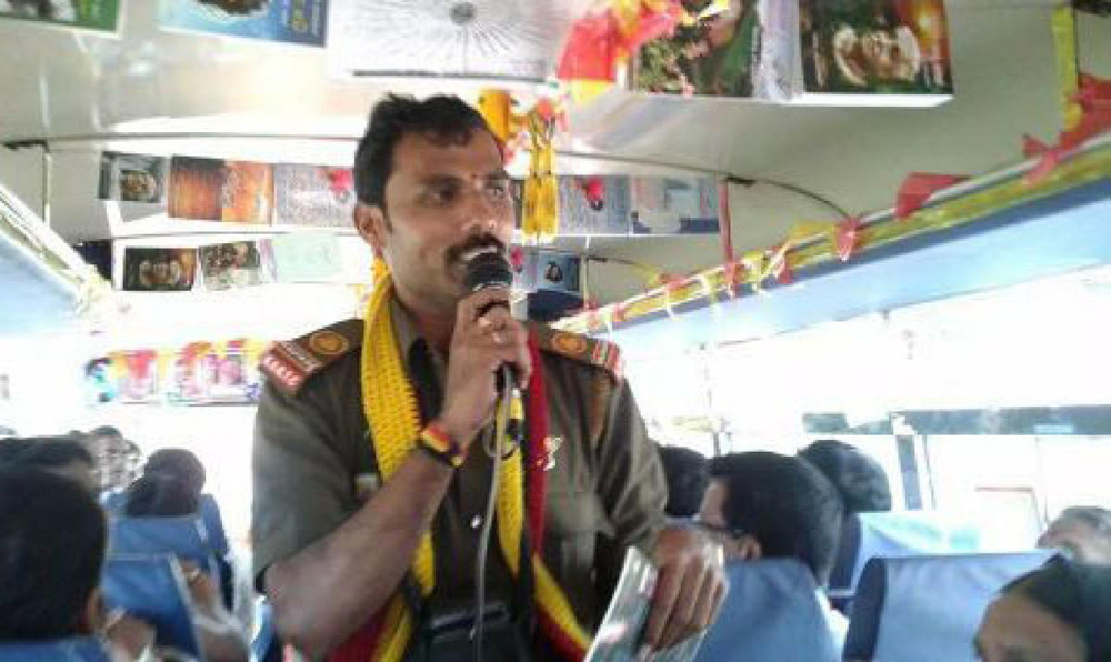 ಪ್ರಯಾಣಿಕರಿಗೆ ಪ್ರಶ್ನೆ ಕೇಳುತ್ತಿರುವ ನಟರಾಜು