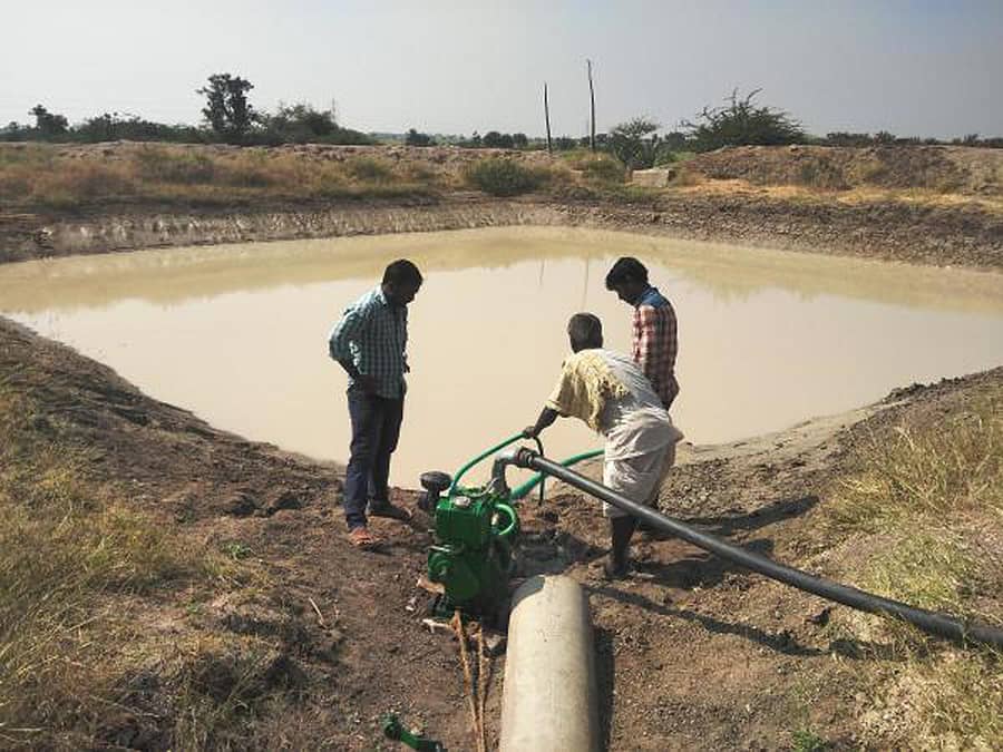 ಬೆಳೆಗಳಿಗೆ ನೀರು ಹಾಯಿಸಲು ಕೃಷಿ ಹೊಂಡಕ್ಕೆ ಆಯಿಲ್ ಪಂಪ್ ಅಳವಡಿಸುತ್ತಿರುವ ರೈತರು