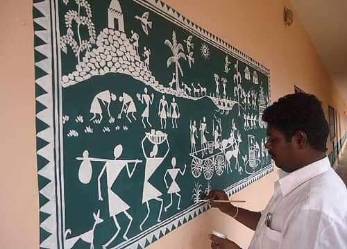 ಚೀಮಂಗಲ ಸರ್ಕಾರಿ ಪ್ರೌಢಶಾಲೆಯ ಗೋಡೆಯ ಮೇಲೆ ವರ್ಲಿ ಚಿತ್ರಕಲೆಯಲ್ಲಿ ಗ್ರಾಮೀಣ ಸೊಗಡಿನ ನೋಟ ಮತ್ತು ಕಲಾವಿದ ನಾಗರಾಜ್‌.