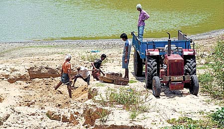 ಬಾಗೇಪಲ್ಲಿ ತಾಲ್ಲೂಕು ಗುಮ್ಮನಾಯಕನಪಾಳ್ಯ ಸಮೀಪದ ಕೆರೆ ಪ್ರದೇಶದಲ್ಲಿನ ಮರಳನ್ನು ಟ್ರ್ಯಾಕ್ಟರ್‌ನಲ್ಲಿ ತುಂಬಿಸುತ್ತಿರುವುದು.