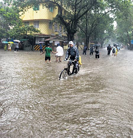 ಮುಂಬೈನ ದಾದರ್ನಲ್ಲಿ ಸೋಮವಾರ ಸುರಿದ ಭಾರಿ ಮಳೆಯಿಂದಾಗಿ ಜನರು ಪ್ರಯಾಸದಿಂದ ಸಂಚರಿಸಿದರು -ಪಿಟಿಐ ಚಿತ್ರ