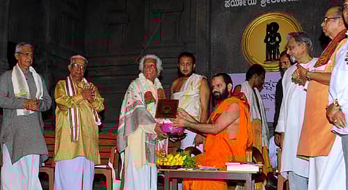 ಉಡುಪಿಯ ಶ್ರೀಕೃಷ್ಣಮಠದ ರಾಜಾಂಗಣದಲ್ಲಿ ಭಾನುವಾರ ನಡೆದ ಕಾರ್ಯಕ್ರಮದಲ್ಲಿ ಪರ್ಯಾಯ ಕಾಣಿಯೂರು ಮಠದ ವಿದ್ಯಾವಲ್ಲಭ ಸ್ವಾಮೀಜಿ ಅವರು ಹೊಸ್ತೋಟ ಮಂಜುನಾಥ ಭಾಗವತರನ್ನು ಸನ್ಮಾನಿಸಿದರು. ಇತಿಹಾಸ ತಜ್ಞ ಪ್ರೊ. ಷ.ಶೆಟ್ಟರ್, ಯಕ್ಷಗಾನ ಅರ್ಥದಾರಿ ಕುಂಬಳೆ ಸುಂದರ ರಾವ್, ಯಕ್ಷಗಾನ ವಿಮರ್ಶಕ ಡಾ.ಎಂ ಪ್ರಭಾಕರ ಜೋಶಿ, ಕರ್ನಾಟಕ ಯಕ್ಷಗಾನ ಆಕಾಡೆಮಿಯ ಮಾಜಿ ಆಧ್ಯಕ್ಷ ಪ್ರೊ. ಎಂ.ಎಲ್ ಸಾಮಗ ಇದ್ದಾರೆ. ಪ್ರಜಾವಾಣಿ ಚಿತ್ರ