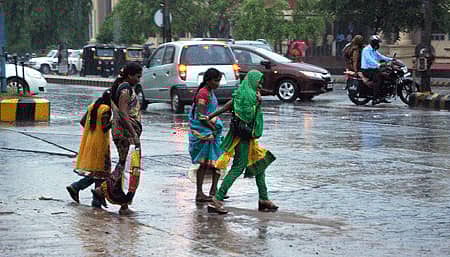 ಮಂಗಳೂರು ನಗರದಲ್ಲಿ ಗುರುವಾರ ಸುರಿದ ಬಿರುಸಿನ ಮಳೆಯಲ್ಲಿ ನೆನಯುತ್ತ ಸಾಗಿದ ಪ್ರಯಾಣಿಕರು