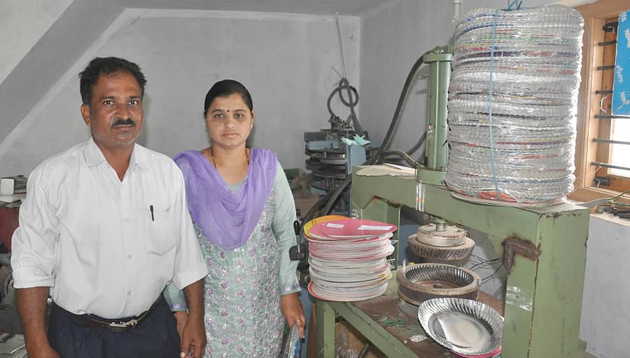 ಹಗರಿಬೊಮ್ಮನಹಳ್ಳಿಯಲ್ಲಿ ಪೇಪರ್ ಪ್ಲೇಟ್ ತಯಾರಿಕೆ ಘಟಕದ ಯಂತ್ರದ ಮುಂದೆ ಬಾಗಲಕೋಟೆ ಶಿವಾನಂದ ಮತ್ತು ಸುರೇಖಾ ದಂಪತಿ