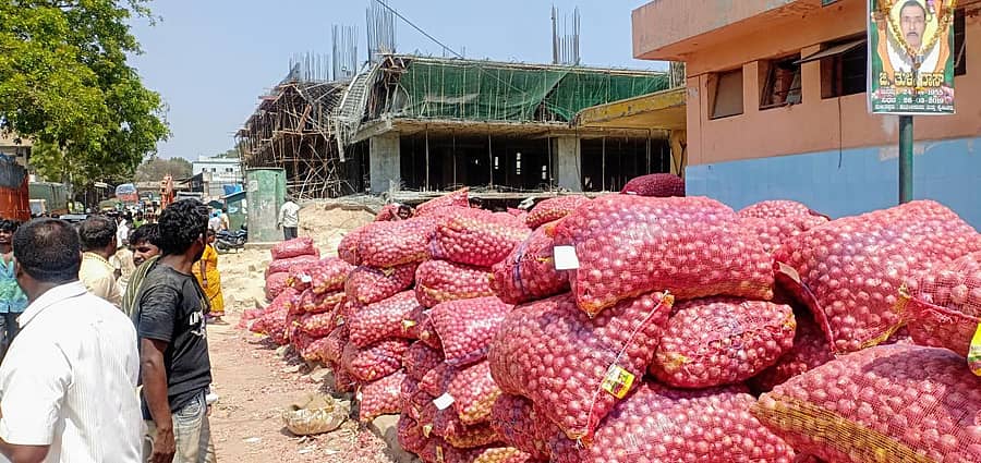 ಪಾರ್ಕಿಂಗ್ ಕಟ್ಟಡಕ್ಕಾಗಿ ‘ಹರಾಜು ಕಟ್ಟೆ’ ಕೆಡವಿದ್ದರಿಂದ ಮಳಿಗೆಗಳಿಲ್ಲದೆ ವರ್ತಕರು ಎಪಿಎಂಸಿ ಆವರಣದಲ್ಲೇ ಈರುಳ್ಳಿ ಮೂಟೆಗಳನ್ನು ಇಳಿಸುತ್ತಿದ್ದಾರೆ