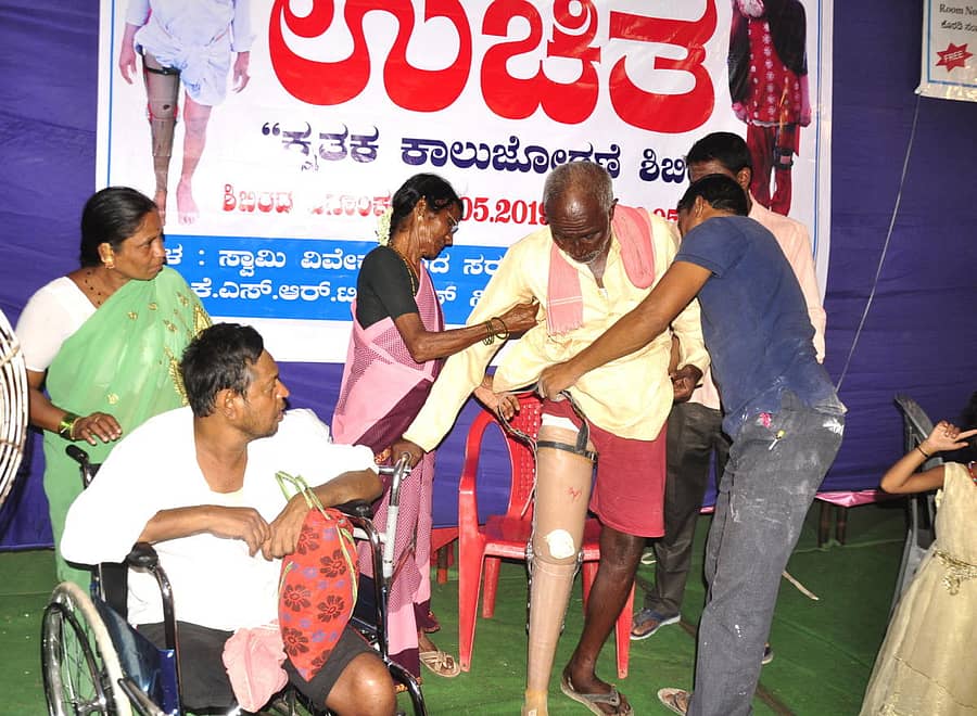 ಹಿರಿಯ ನಾಗರಿಕರಿಗೆ ಕೃತಕ ಕಾಲು ಜೋಡಿಸುತ್ತಿರುವುದು