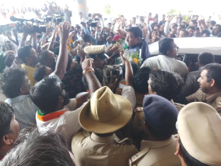 ತಮ್ಮನ್ನು ಸ್ವಾಗತಿಸಲು ವಿಮಾನ ನಿಲ್ದಾಣಕ್ಕೆ ಬಂದಿದ್ದ ಕಾರ್ಯಕರ್ತರತ್ತ ಕೈಬೀಸಿದ ಕೇಂದ್ರ ಸಚಿವ ಪ್ರಹ್ಲಾದ ಜೋಶಿ–