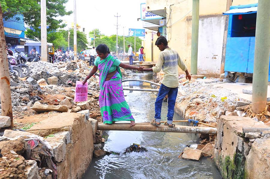ಮಹಿಳೆಯೊಬ್ಬರು ಮಗನ ಸಹಾಯದಿಂದ ಕಾಲುವೆ ದಾಟುತ್ತಿರುವುದು. ಹೊಸಪೇಟೆಯ ಗಾಂಧಿ ನಗರದಲ್ಲಿ ರಾಜಕಾಲುವೆ ನಿರ್ಮಾಣ ಕಾಮಗಾರಿ ಕೈಗೆತ್ತಿಕೊಂಡಿರುವ ಕಾರಣ ಸಾರ್ವಜನಿಕರು ಜೀವ ಕೈಯಲ್ಲಿ ಹಿಡಿದುಕೊಂಡು ಓಡಾಡುತ್ತಿದ್ದು, ನಿತ್ಯ ಈ ದೃಶ್ಯ ಸಾಮಾನ್ಯವಾಗಿದೆ