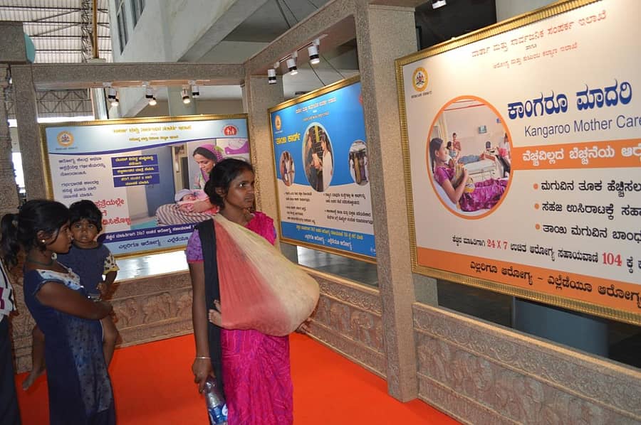 ಹಾಸನದ ಕೆಎಸ್ಆರ್ಟಿಸಿ ಬಸ್ ನಿಲ್ದಾಣದಲ್ಲಿ ಆಯೋಜಿಸಿರುವ ಜಾಗೃತಿ ಕಾರ್ಯಕ್ರಮದಲ್ಲಿ ಆರೋಗ್ಯ ಇಲಾಖೆ ಫಲಕ ವೀಕ್ಷಿಸುತ್ತಿರುವ ಮಹಿಳೆ.