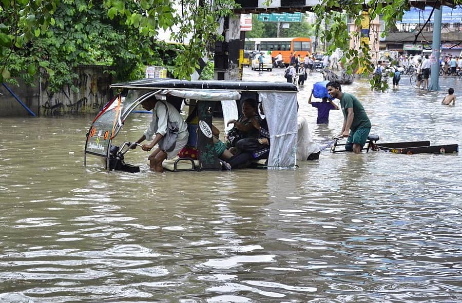 ಉತ್ತರ ಪ್ರದೇಶದ ಮಥುರಾದಲ್ಲಿ ಭಾರಿ ಮಳೆಯಿಂದ ಜಲಾವೃತಗೊಂಡಿರುವ ರಸ್ತೆಯಲ್ಲಿ ಪ್ರಯಾಣಿಕರನ್ನು ಕರೆದುಕೊಂಡು ಹೋಗಲು ಹರಸಾಹಸ ಪಡುತ್ತಿರುವ ಆಟೊ ಚಾಲಕ – ಎಎಫ್ಪಿ ಚಿತ್ರ