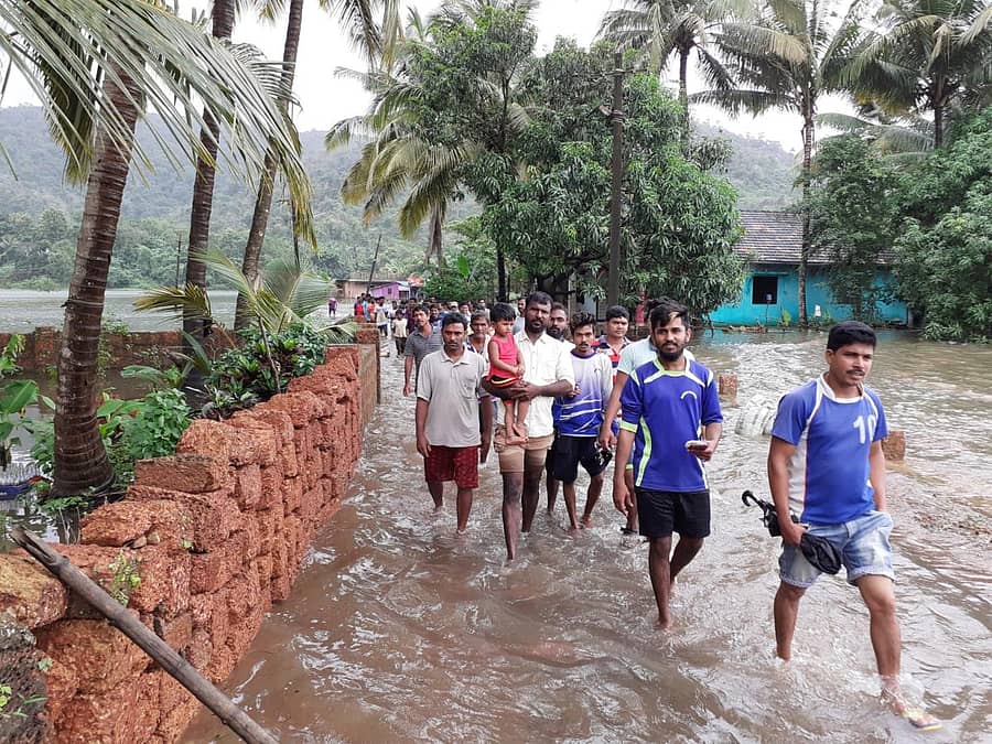 ಕಾರವಾರ ತಾಲ್ಲೂಕಿನ ಘಾಡಸಾಯಿ ಗ್ರಾಮದಲ್ಲಿ ಜಲಾವೃತವಾದ ಜಮೀನಿನಲ್ಲಿ ಗ್ರಾಮಸ್ಥರು ಶುಕ್ರವಾರ ಹೆಜ್ಜೆ ಹಾಕುತ್ತ ಸುರಕ್ಷಿತ ಸ್ಥಳದತ್ತ ಬರುತ್ತಿರುವುದು. 