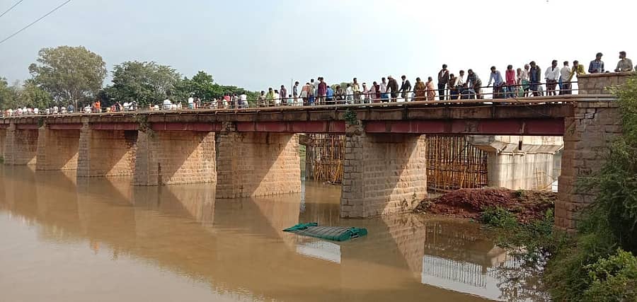 ಹೊಸದುರ್ಗ ತಾಲ್ಲೂಕಿನ ಕೆಲ್ಲೋಡು ಬಳಿ ವೇದಾವತಿ ನದಿಗೆ ಪಲ್ಟಿಯಾಗಿರುವ ವಾಹನ ವೀಕ್ಷಿಸುತ್ತಿರುವ ಜನರು.