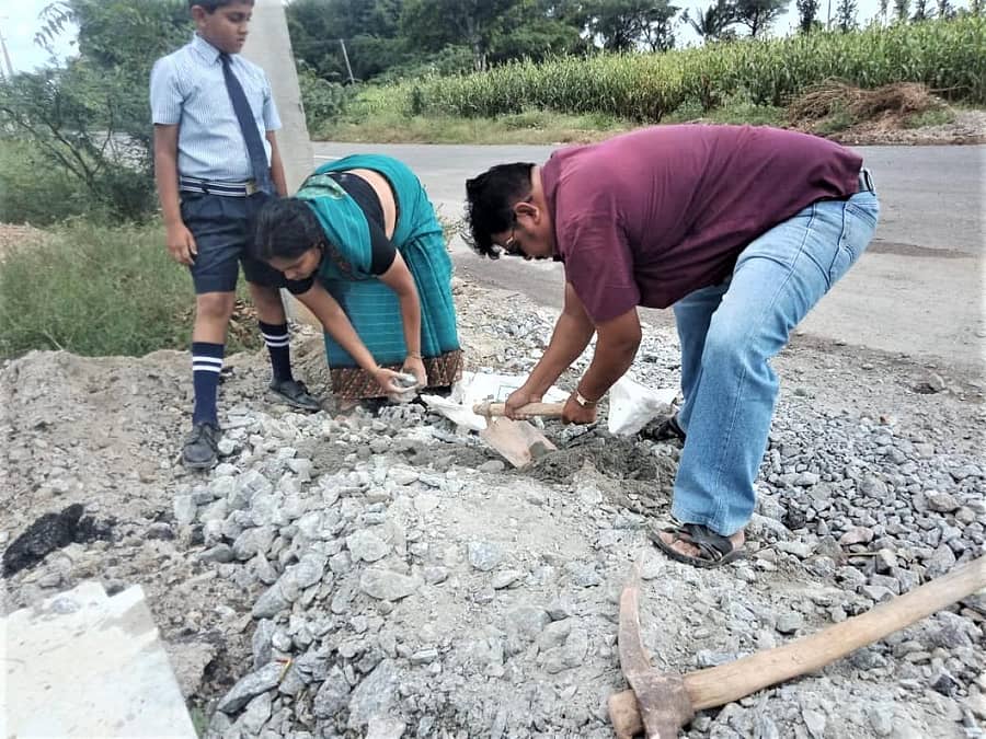 ಪುರವರ ಸಮೀಪದ ಹಿಂದೂಪುರ-ಮಧುಗಿರಿ ಮುಖ್ಯ ರಸ್ತೆಯಲ್ಲಿ ಗುಂಡಿ ಬಿದ್ದಿರುವುದನ್ನು ಮುಚ್ಚುತ್ತಿರುವ ಶಿಕ್ಷಕ ದಂಪತಿ