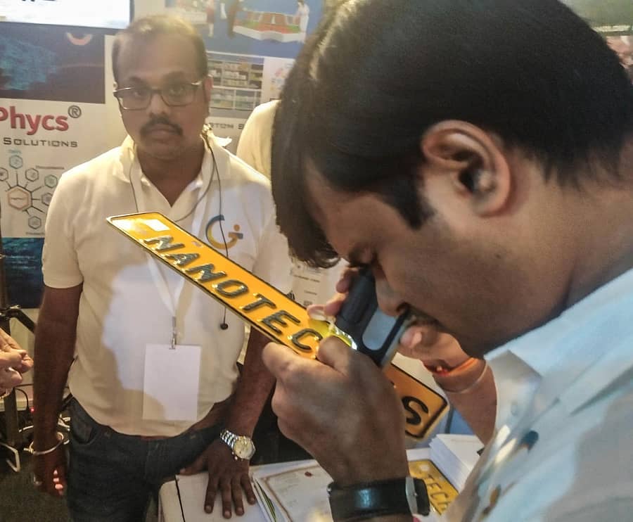 ನಂಬರ್‌ ಪ್ಲೇಟ್‌ನಲ್ಲಿರುವ ಸಂಕೇತವುಳ್ಳ ನ್ಯಾನೊ ಕಣಗಳನ್ನು ವೀಕ್ಷಿಸುತ್ತಿರುವ ವ್ಯಕ್ತಿ– ಪ್ರಜಾವಾಣಿ ಚಿತ್ರ