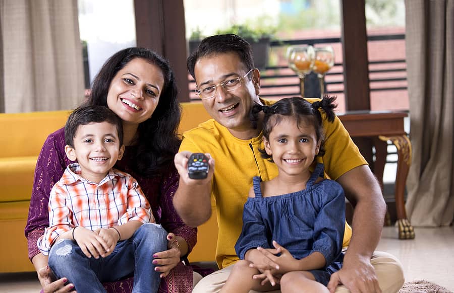 Happy Indian family watching TV at homeFamily watching TV