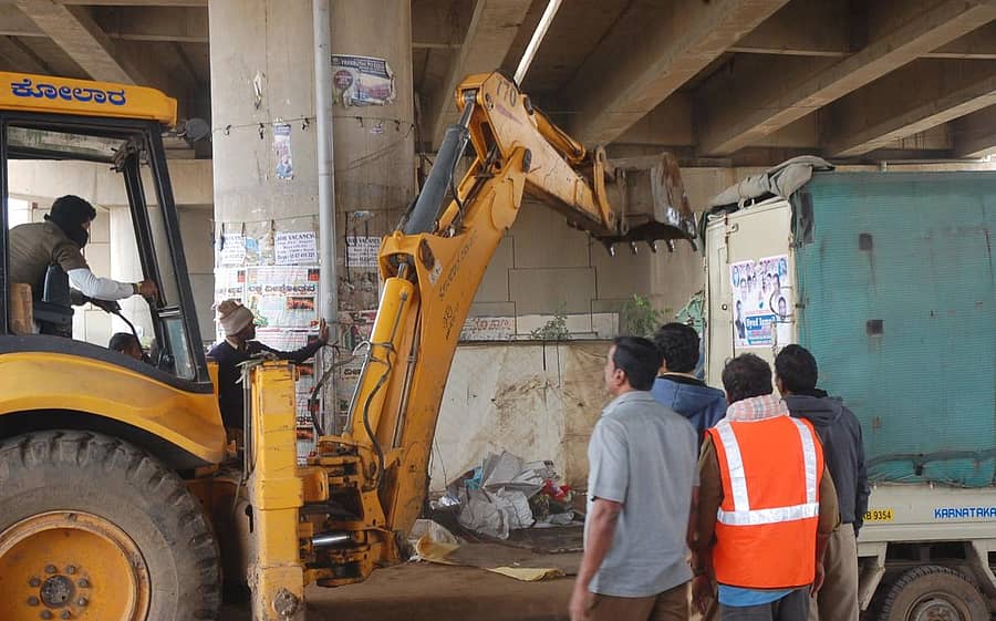 ಕೋಲಾರ ಎಪಿಎಂಸಿ ಬಳಿಯ ಪಾದಚಾರಿ ಮಾರ್ಗದಲ್ಲಿನ ಅಂಗಡಿಗಳನ್ನು ನಗರಸಭೆ ಅಧಿಕಾರಿಗಳು ಮಂಗಳವಾರ ಜೆಸಿಬಿ ವಾಹನದಿಂದ ತೆರವುಗೊಳಿಸಿದರು.