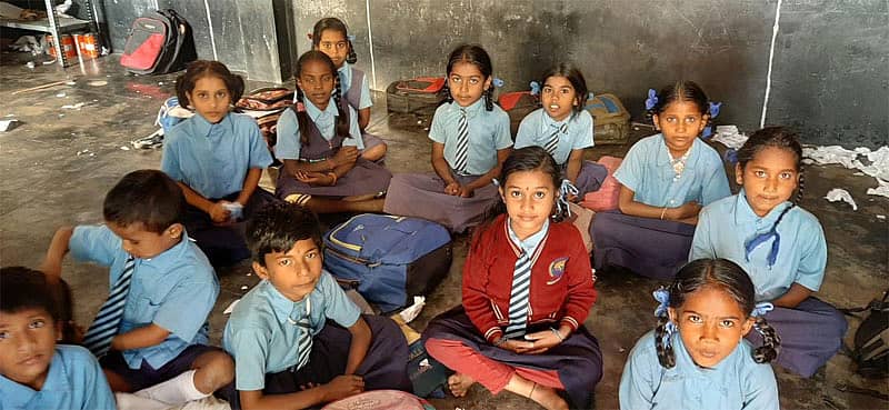 ನೆಲದಲ್ಲೇ ಕುಳಿತು ಪಾಠ ಕೇಳುವ ವಿದ್ಯಾರ್ಥಿಗಳು