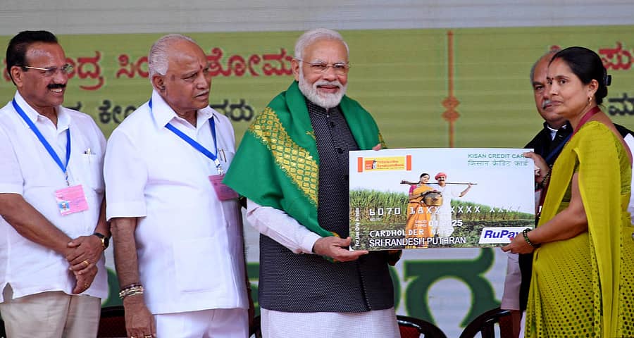 ತುಮಕೂರಿನಲ್ಲಿ ಗುರುವಾರ ನಡೆದ ರೈತ ಸಮಾವೇಶದಲ್ಲಿ ಪ್ರಧಾನಿ ನರೇಂದ್ರ ಮೋದಿ ಅವರು ಕಾರವಾರದ ಮೀನುಗಾರ ಕುಟುಂಬದ ಸುಪ್ರಿಯಾ ಸುಧೀರ್‌ ಸಾರಂಗ್‌ ಅವರಿಗೆ ಕಿಸಾನ್‌ ಕ್ರೆಡಿಟ್‌ ಕಾರ್ಡ್‌ ವಿತರಿಸಿದರು. ಕೇಂದ್ರ ಸಚಿವ ಡಿ.ವಿ.ಸದಾನಂದಗೌಡ, ಮುಖ್ಯಮಂತ್ರಿ ಬಿ.ಎಸ್‌.ಯಡಿಯೂರಪ್ಪ ಇದ್ದಾರೆ.  – ಪ್ರಜಾವಾಣಿ ಚಿತ್ರ