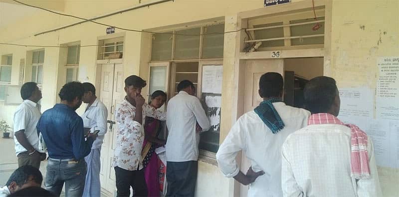 ಪಡಿತರ ಚೀಟಿಗೆ ಸಂಬಂಧಿಸಿದ ಕೆಲಸಕ್ಕಾಗಿ ತಾಲ್ಲೂಕು ಕಚೇರಿಯ ಆಹಾರ ಶಾಖೆಯ ಮುಂದೆ ಸೇರಿರುವ ಜನರು